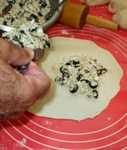 Filling is measured onto the calzone dough rounds before sealing.